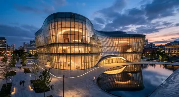 Futuristic glass museum building glowing at blue hour with modern architectural design