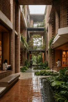 Portrait view of a contemporary brick civic reading cloister surrounding a rain garden lightwell with layered galleries, reflective water channels, planted terraces, and anonymous visitors.